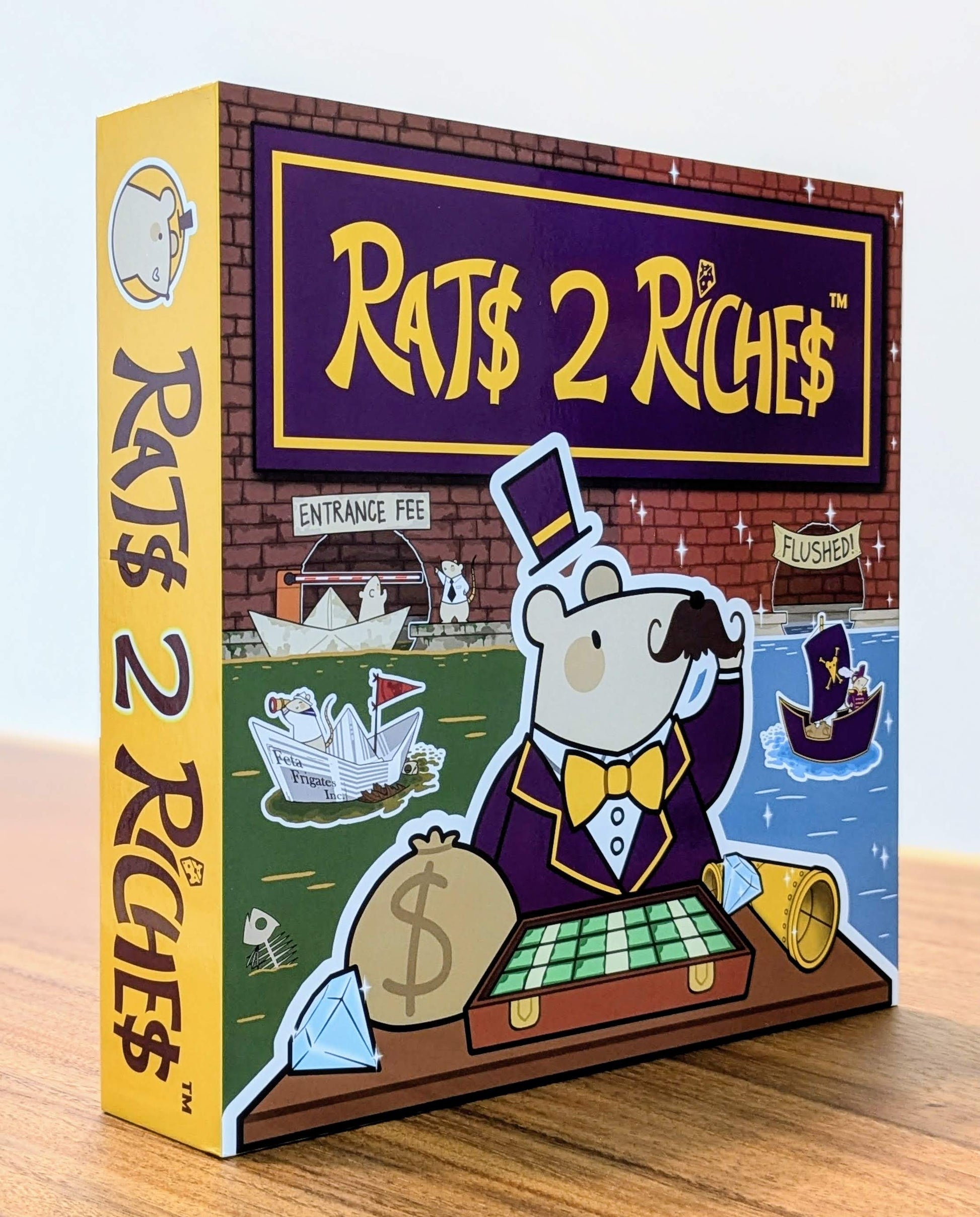 Board game box titled 'Rats 2 Riches' on a wooden surface